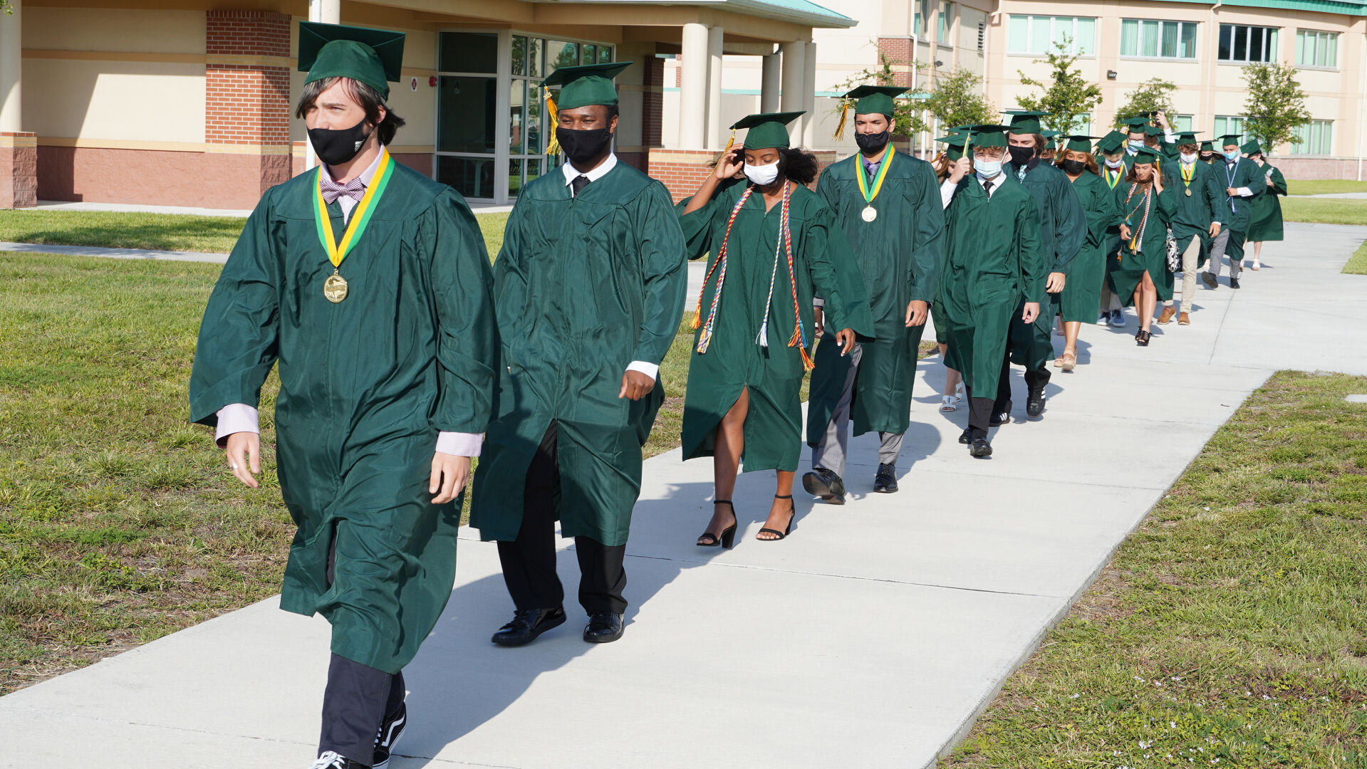 Melbourne Central Catholic High School students head to the field for graduation May 21.